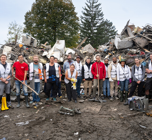 Eine Gruppe von ehrenamtlichen Helfer*innen, die nach dem Hochwasser in Niederösterreich bei den Aufräumarbeiten geholfen hat. © Caritas / Stefanie J. Steindl Gruppe von Ehrenamtlichen räumt Schutt nach Naturkatastrophe gemeinsam auf
