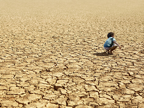 Child Playing on Dry Parched Desert Land